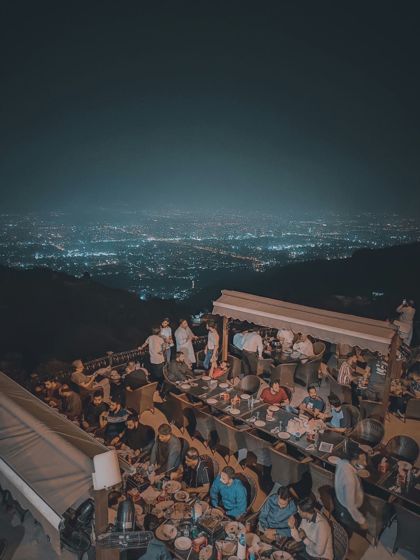 Rooftop gathering above city lights